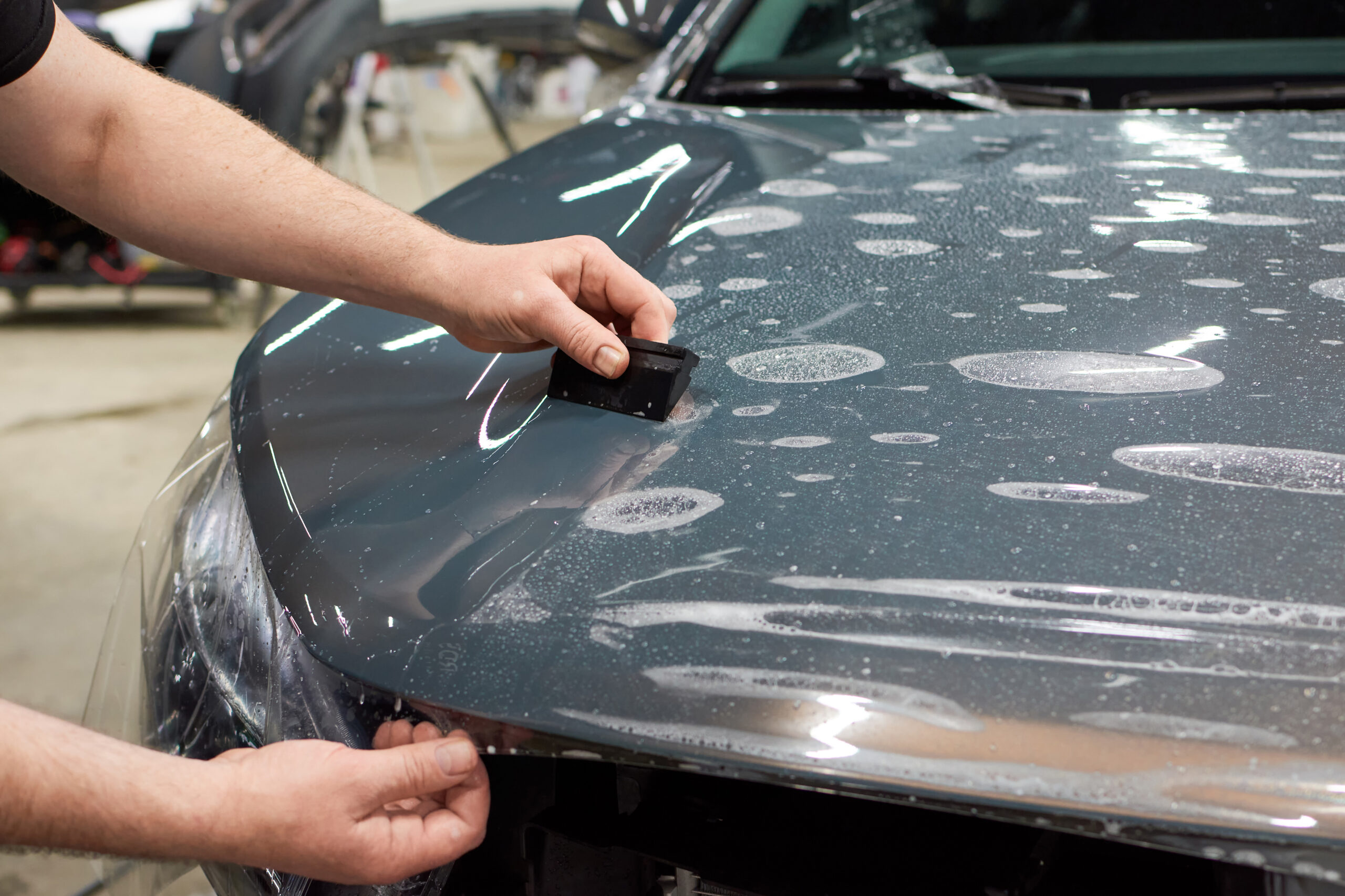 nstallation of a protective paint and varnish transparent film on the car. PPF polyurethane film to protect the car paint from stones and scratches.